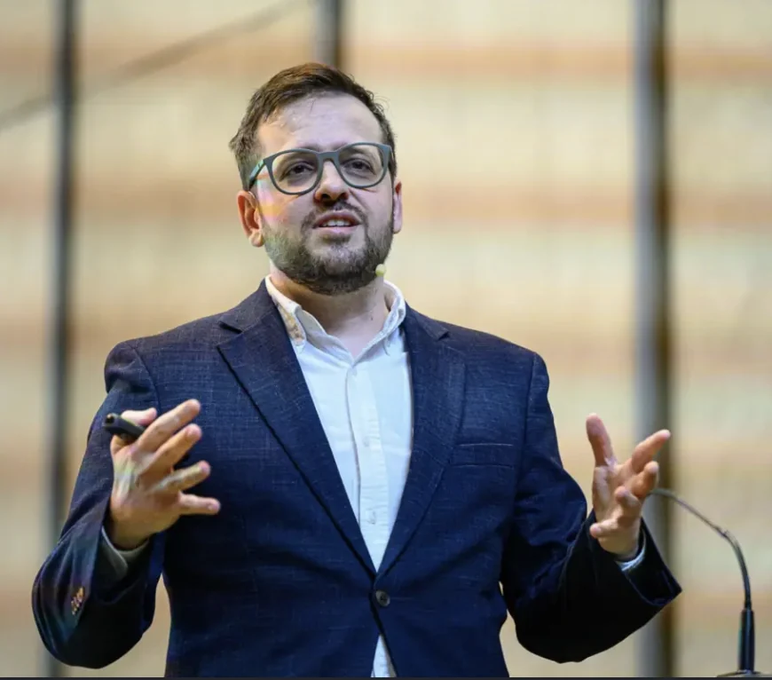 Nuno Palma numa apresentação, de blazer azul, a falar em palco